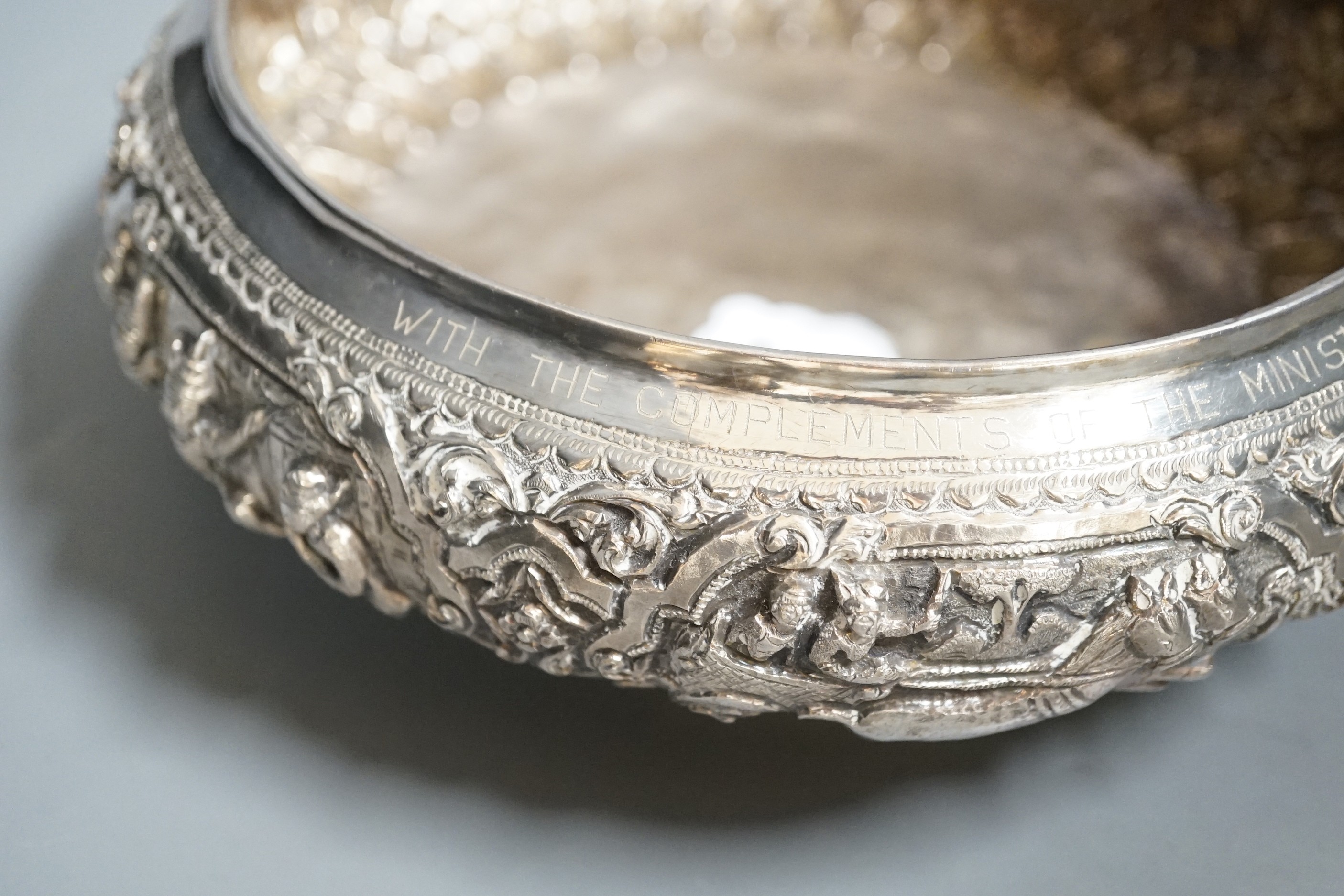 An Indian repousse white metal presentation bowl, with engraved inscription, diameter 21.5cm and a similar smaller bowl